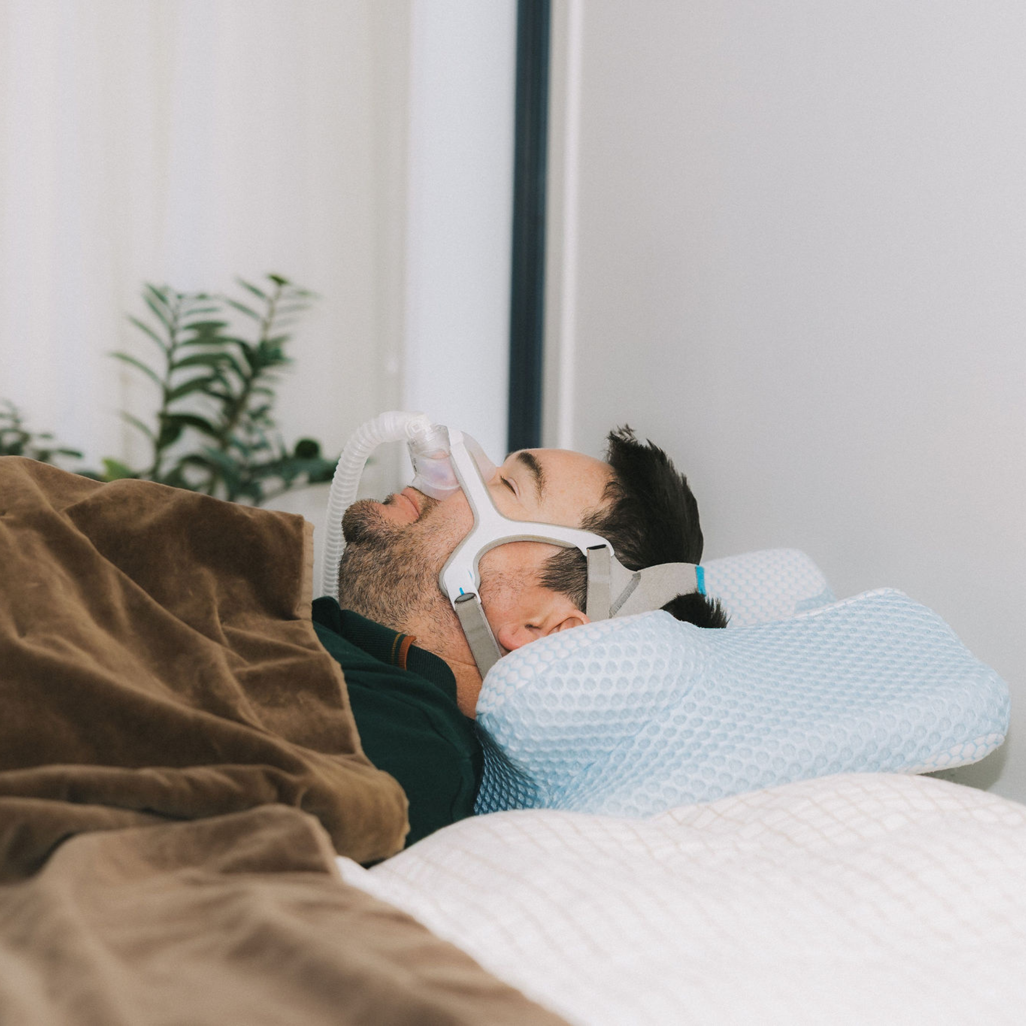 Person using a CPAP machine comfortably with the Dream Sleep ergonomic posture pillow.