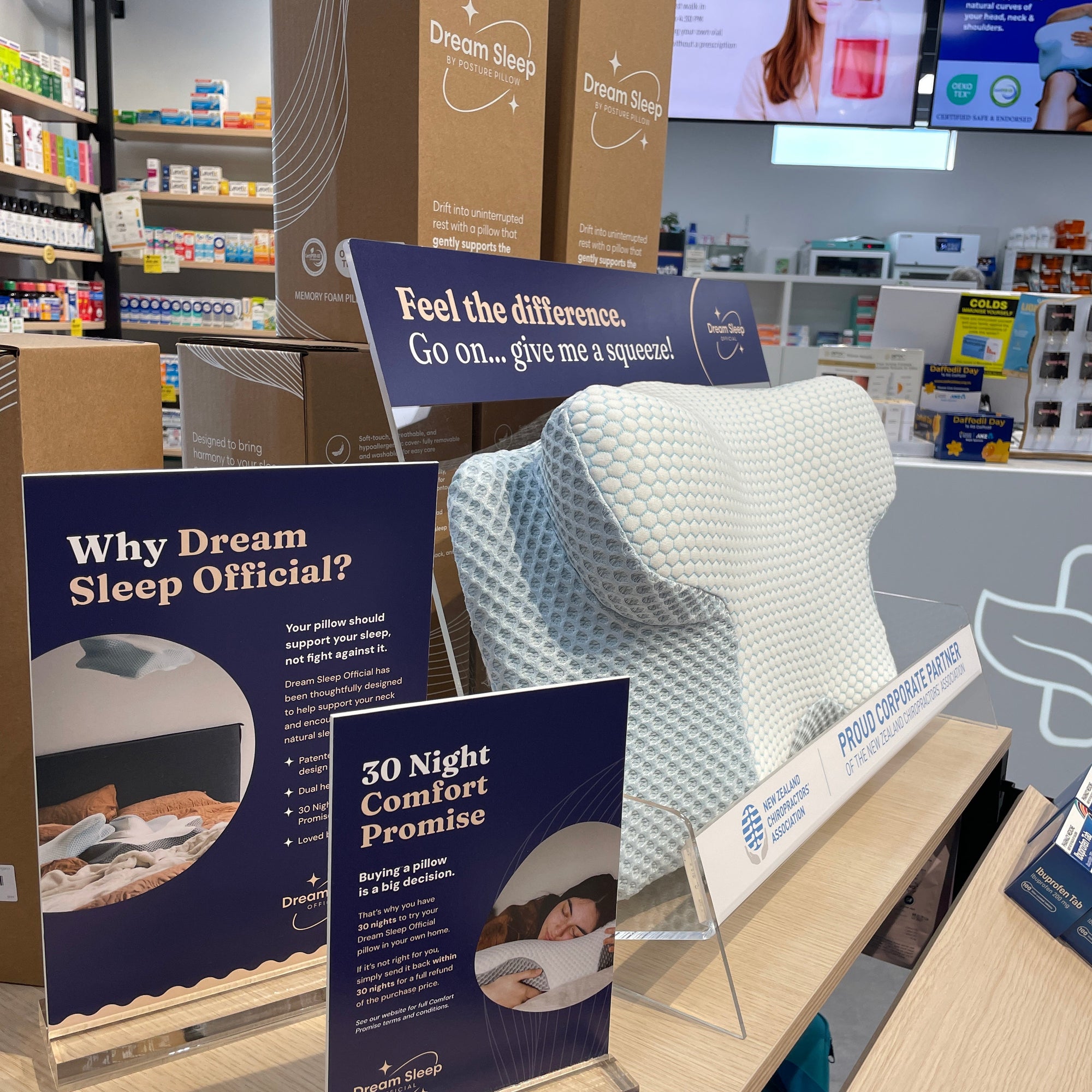 A Dream Sleep brand contoured pillow displayed on a retail counter alongside promotional signs and product boxes in Your Pharmacy Mount Maunganui