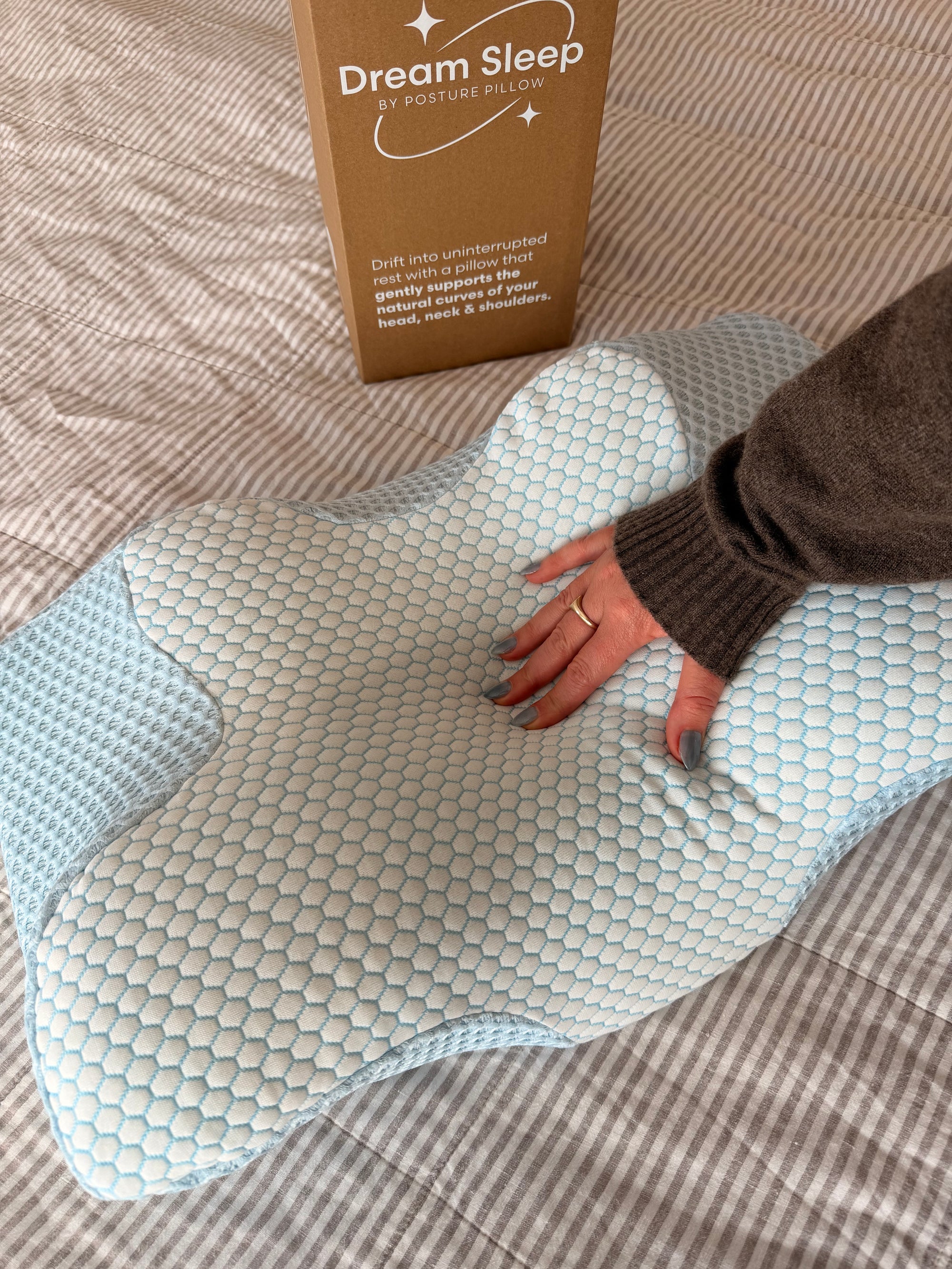 A hand pressing into a Dream Sleep orthopaedic pillow, showcasing the pressure-relieving fabric designed to stop overheating.