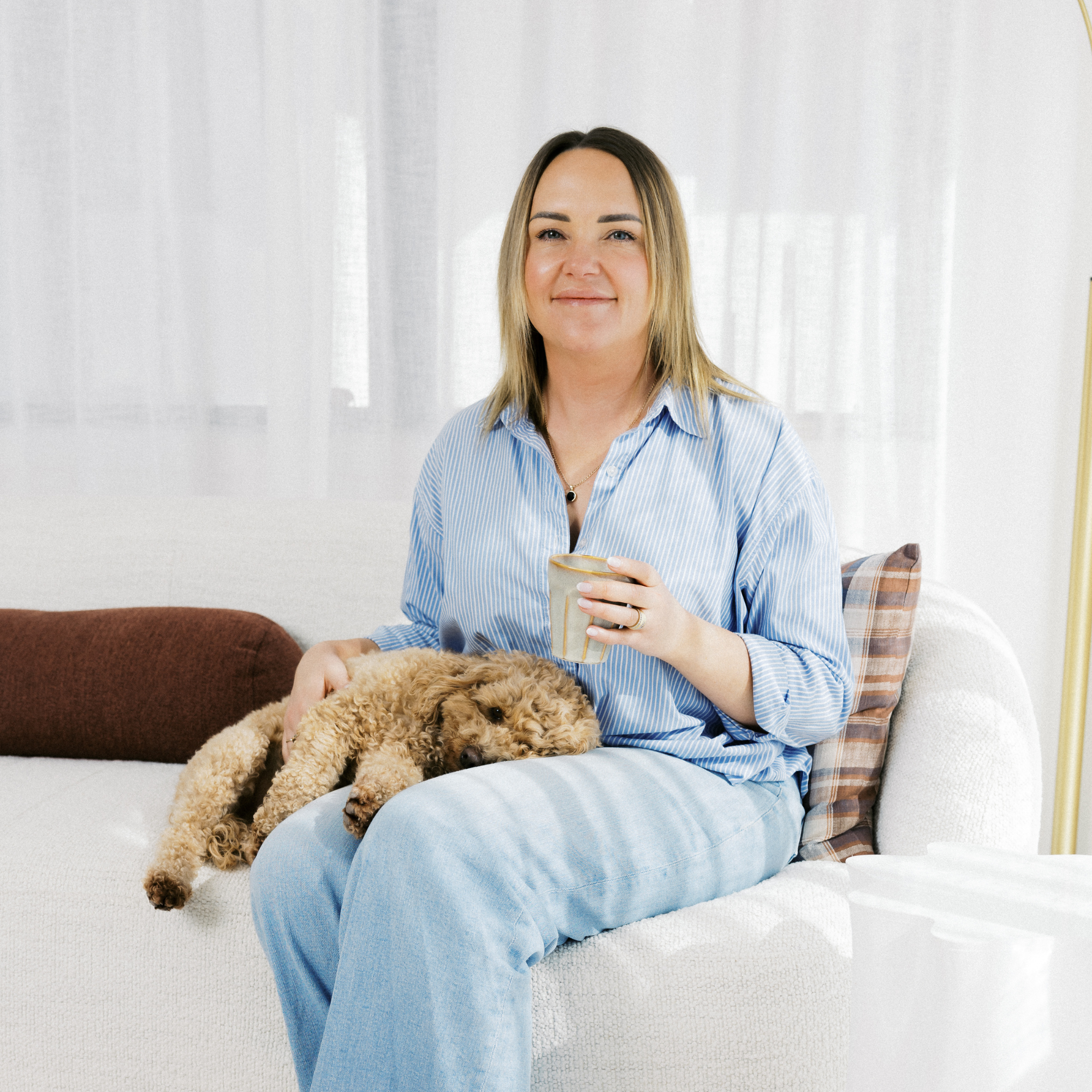 Fern Cumming, founder and designer of the Dream Sleep ergonomic pillow, in a cosy, well-lit bedroom setting.