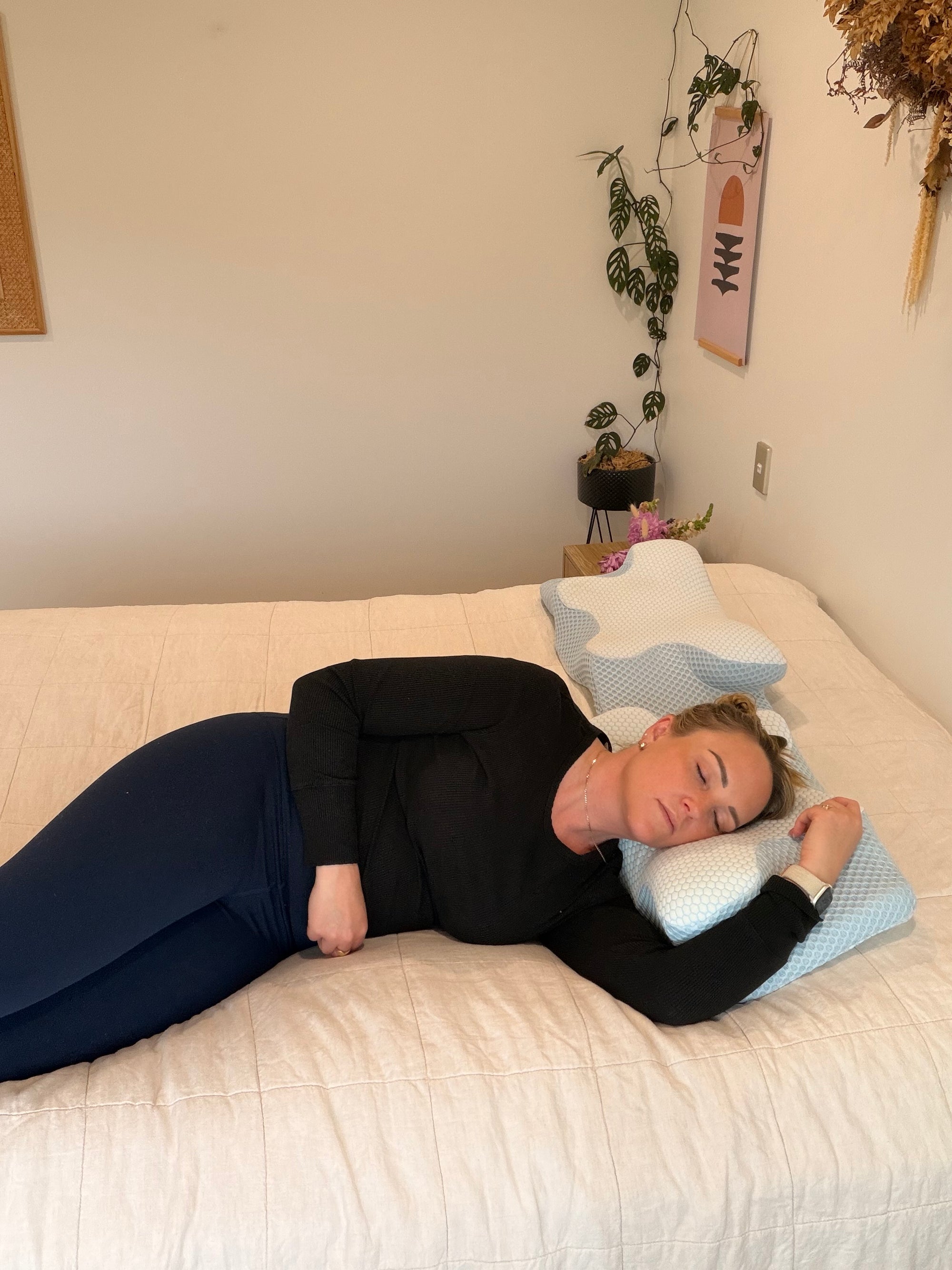A person side-sleeping on a Dream Sleep orthopaedic pillow, demonstrating proper neck alignment and ergonomic support.
