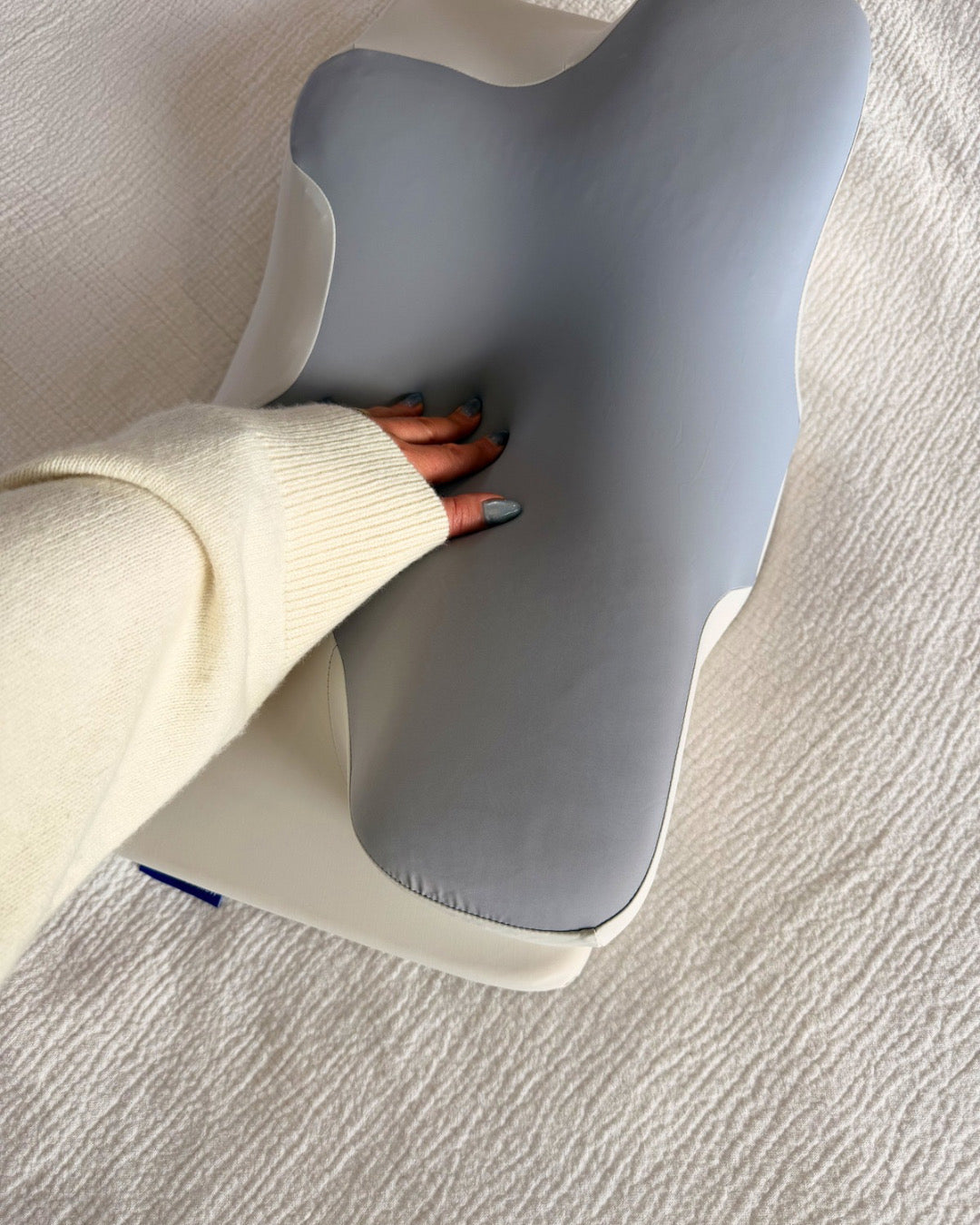 A hand resting on the Dream Sleep pillowcase, demonstrating the soft, pressure-relieving, and temperature-neutral fabric surface.