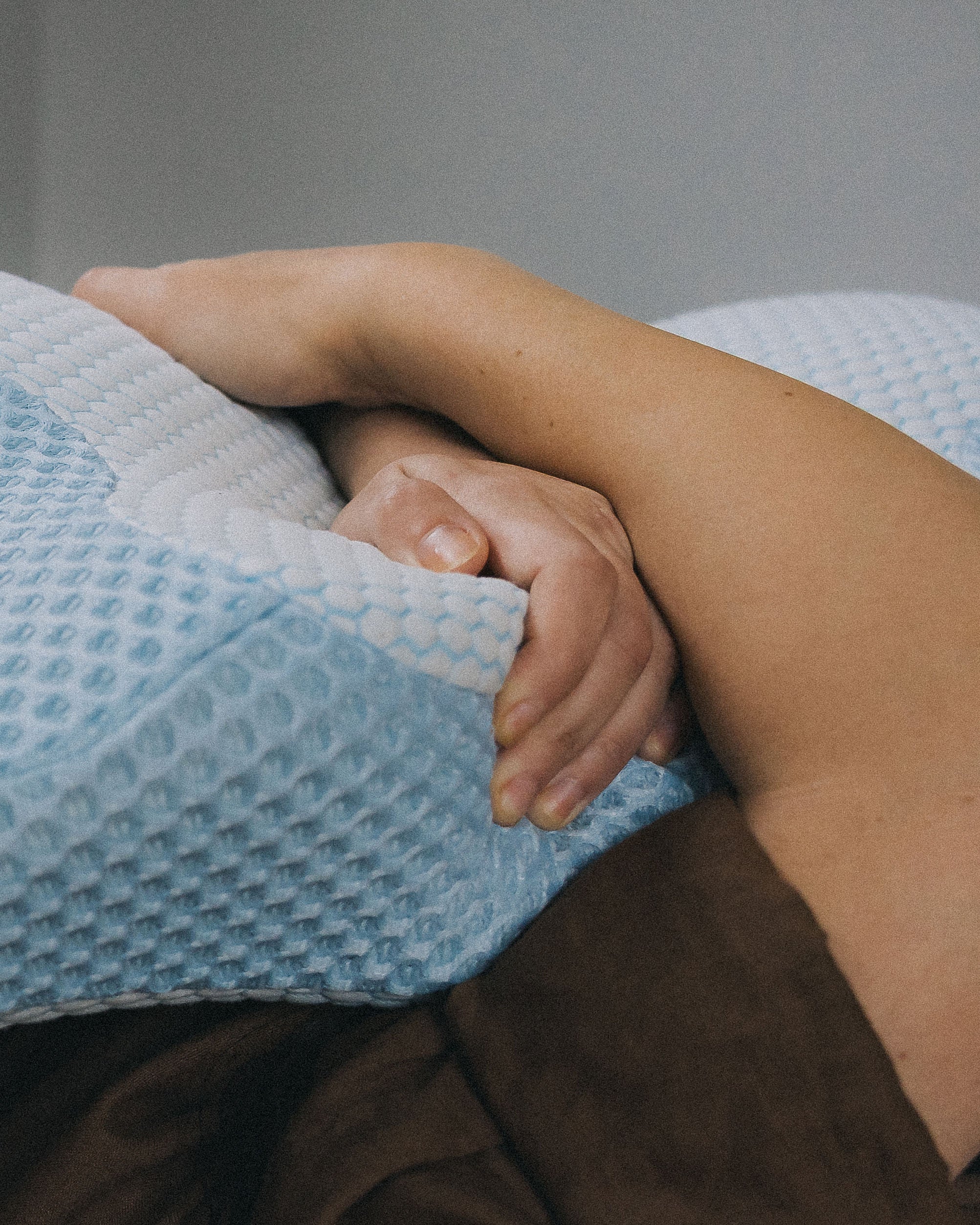 Close-up of arm resting on the Blue Posture Pillow, highlighting the soft, breathable, cool-touch fabric for superior comfort.