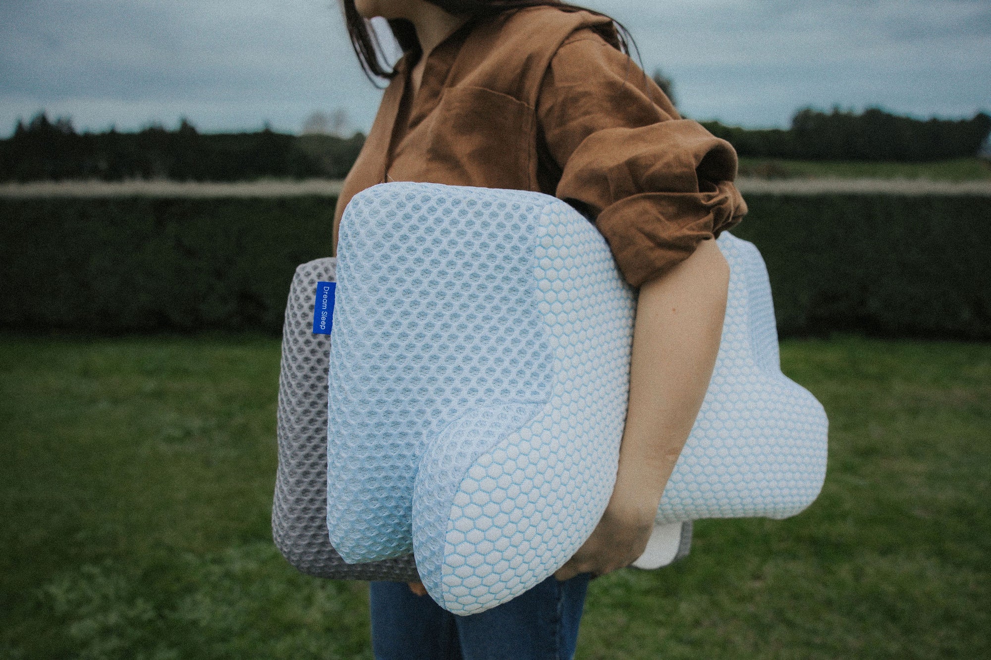 Two Blue Posture Pillows viewed from the side, showing the dual-height ergonomic contour for customizable orthopaedic support.