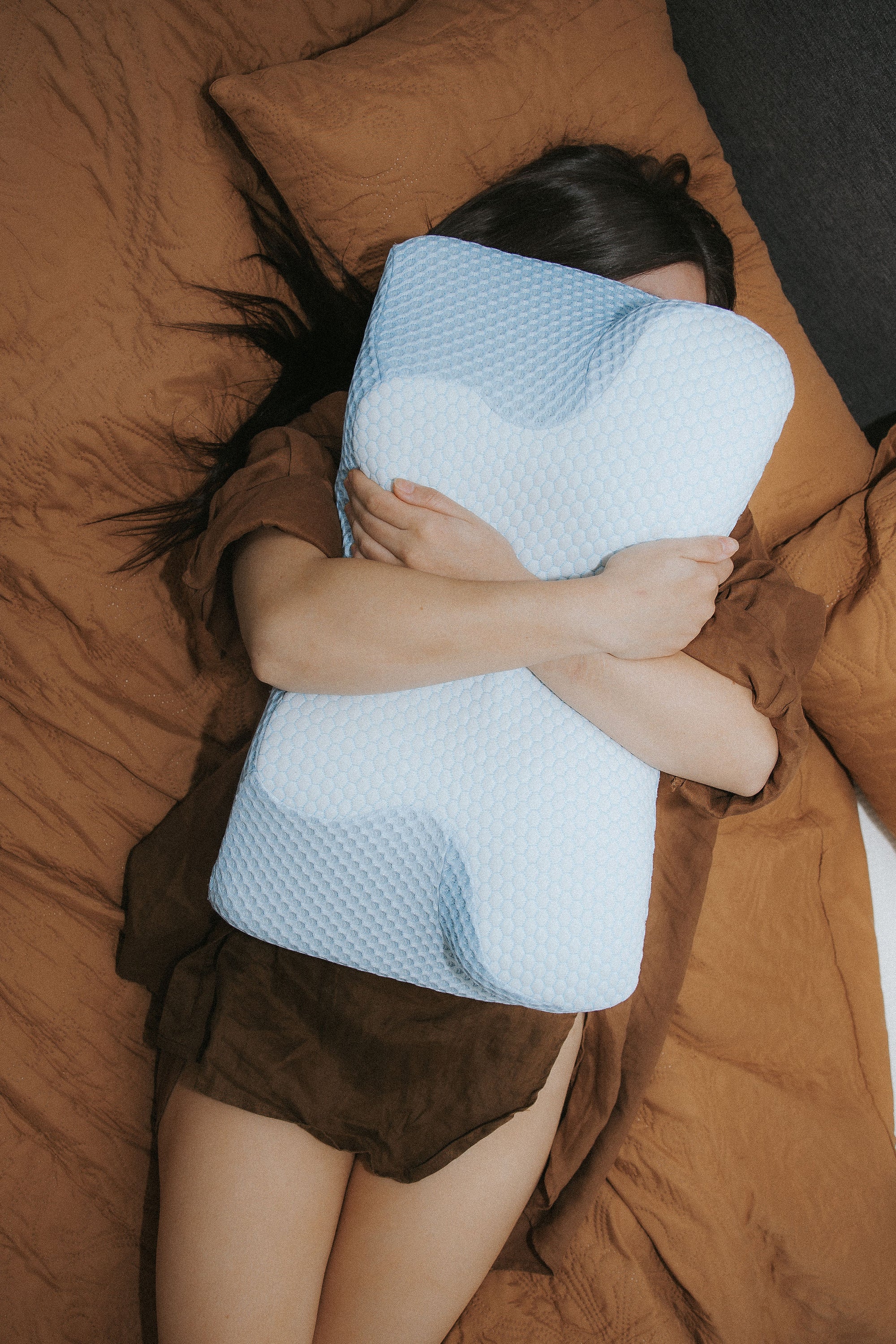 The Dream Sleep Alpine Blue luxury posture pillow, shown in a modern bedroom setting. This essential ergonomic sleeping aid provides the firm, reliable support needed for long-term spinal health and deep pain relief.
