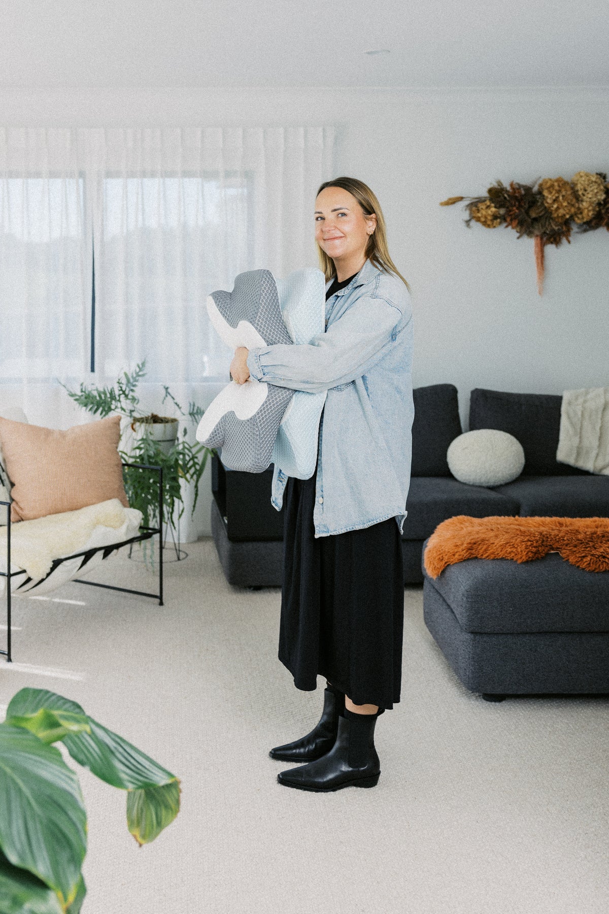Fern, founder of Dream Sleep in New Zealand, showing an orthopaedic pillow designed to relieve chronic neck pain and improve posture.