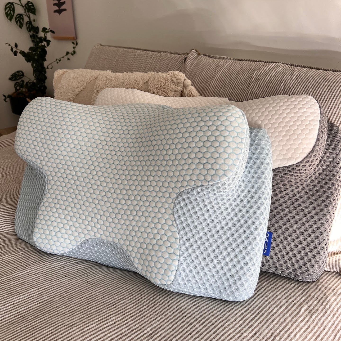 Lifestyle shot of the Signature Twin Pillow Set featuring Alpine Blue and Cloud Grey ergonomic contour memory foam pillows displayed on a bed for a comfortable, supportive sleep environment.