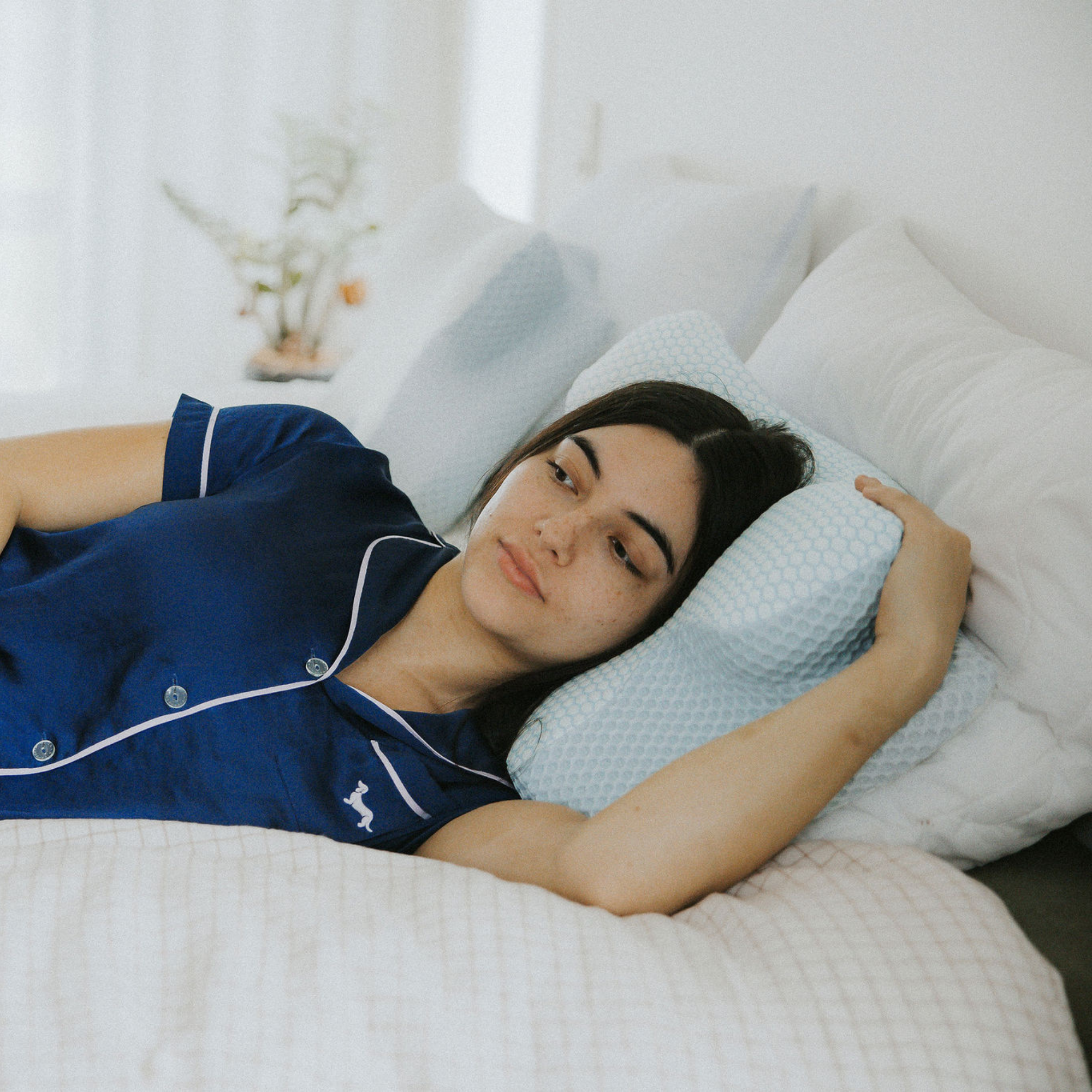 Woman resting comfortably on an ergonomic contour pillow for side sleepers.